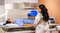 Diagnostic radiologist performs fluroscopy exam on patient.